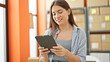 © Krakenimages.com - Young beautiful hispanic woman ecommerce business worker smiling confident using touchpad at office