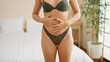 © Krakenimages.com - Young beautiful hispanic woman wearing lingerie touching belly at bedroom