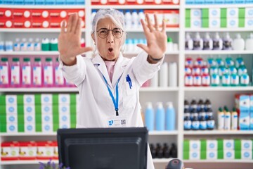 Poster - Middle age woman with tattoos working at pharmacy drugstore doing stop gesture with hands palms, angry and frustration expression