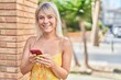 © Krakenimages.com - Young blonde woman smiling confident using smartphone at street