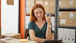 Young redhead woman ecommerce business worker sending voice message by smartphone at office