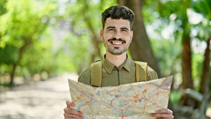 Sticker - Young hispanic man tourist wearing backpack looking map at park