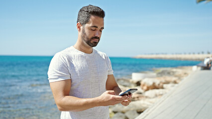 Sticker - Young hispanic man using smartphone at the beach