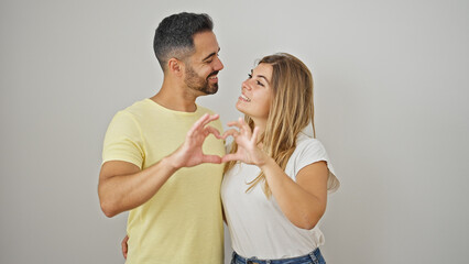 Poster - Man and woman couple hugging each other doing heart gesture over isolated white background