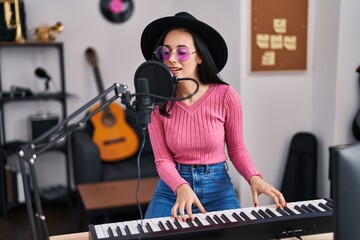 Sticker - Young caucasian woman musician singing song playing piano at music studio