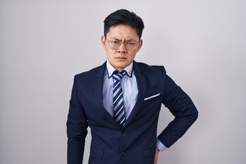 Sticker - Young asian man wearing business suit and tie skeptic and nervous, frowning upset because of problem. negative person.