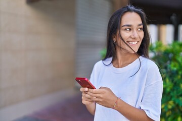 Canvas Print - Young beautiful hispanic woman smiling confident using smartphone at street
