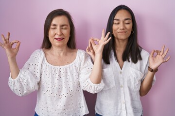 Poster - Hispanic mother and daughter together relaxed and smiling with eyes closed doing meditation gesture with fingers. yoga concept.