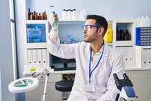 Young Hispanic Man Scientist Holding Test Tubes At Laboratory