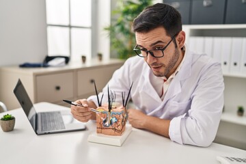 Poster - Young hispanic man dermatologist working at clinic