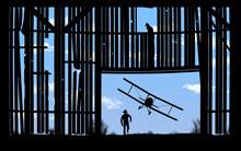 A Barnstorming Bi-plane Flies Low And Is Seen Through The Doorway Of An Old Farm Barn In An Illustration About The 1920s Aerial Shows.