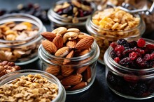 Healthy Snack  Healthy Food. Granola, Nuts, Dried Cranberries, Raisins, Almonds In Glass Jars On Black Background