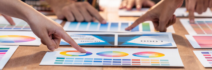 Fototapete - Graphic designer brainstorm logo and graphic art at busy creative studio workshop. Experiment and brainstorm color palette and pattern at workspace table for creative design. Panorama shot. Scrutinize