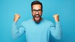 young handsome man with beard wearing casual sweater and glasses over blue background very happy and excited doing winner gesture with arms raised, smiling, generative ai