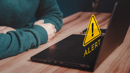 Man working on computer laptop with octagonal shape warning sign for notification error. Technology and maintenance concept of computer virus detected, network security and personal data protection.