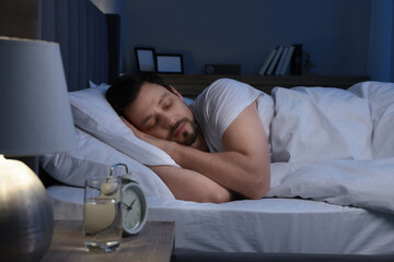 Canvas Print - Handsome man sleeping in bed at night