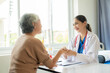 © ArLawKa - Family doctor examining smiling asian old woman using stethoscope at hospital An old woman talks and consults with a doctor about osteopathy. Health and wellness concept