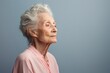 © Tuyres - Portrait of a fictional elderly woman isolated on a light blue background. Generative AI.