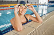 © Ilzer/peopleimages.com - Portrait, swimming pool and happy woman with goggles for exercise, workout or sports. Face, swim athlete and person smile for fitness, training and wellness, healthy body and confidence in Australia