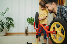 Son Learning To Repair Bicycle At Home