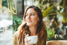 Thoughtful Young Woman With Coffee Cup In Cafe