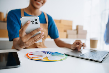 Wall Mural - Young woman holding a smartphone, tablet showing payment success and credit card with yellow parcel box as online shopping concept