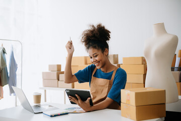 Wall Mural - Young woman holding a smartphone, tablet showing payment success and credit card with yellow parcel box as online shopping concept