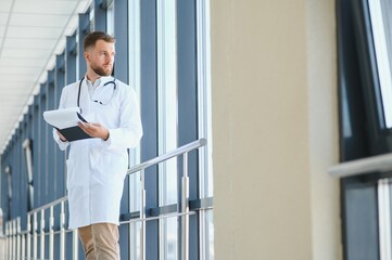 Wall Mural - Portrait of a male doctor standing in a hospital corridor.