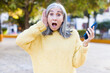 © kues1 - pretty senior woman feeling extremely shocked and surprised with a smartphone