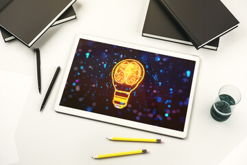 Creative idea concept with light bulb and human brain illustration on modern digital tablet screen. Neural networks and machine learning concept. Top view. 3D Rendering