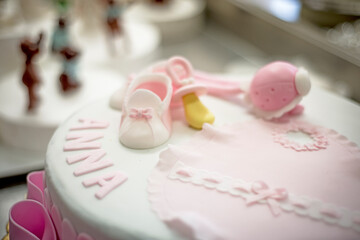 3 tier frosted birthday cake decorated with pastel pink, yellow and white flowers.