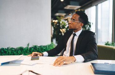 Sticker - Black businessman in suit sitting at table in workspace