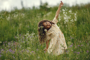 Wall Mural - Cute little girl playing in a summer field