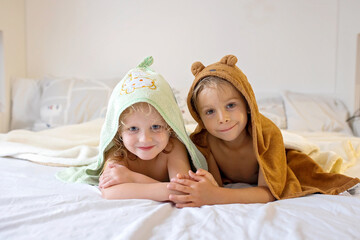 Poster - Two cute blond beautiful children, boy and girl, lying on the bed after bath, cuddling