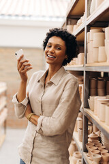 Wall Mural - Female entrepreneur smiling at the camera in her ceramic shop