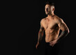 © A Stock Studio - Strong muscular man on a black background, studio photo. Bodybuilding, torso muscles.