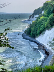 Wall Mural - Waves in sea near coastline on empty pebble beach.