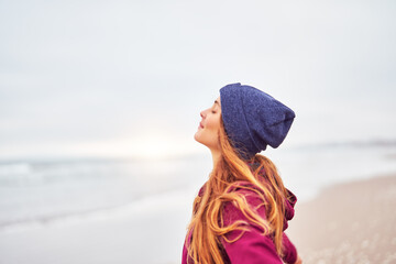 head shot portrait beautiful young caucasian woman with eyes closed on the beach enjoying the breeze