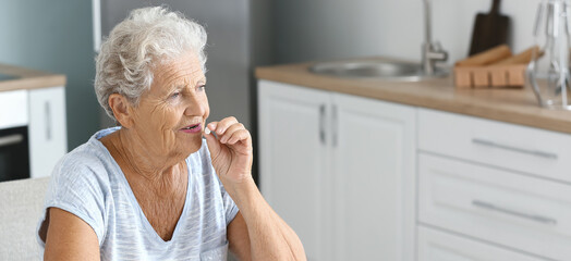 Sticker - Elderly woman with glass of water taking medicines at home