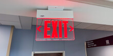 Red Exit Sign Above The Door, A Symbol Of Safety, Escape, And A Way Out In Emergencies. Represents Hope And Assurance In Uncertain Situations. Concept Of Finding An Exit
