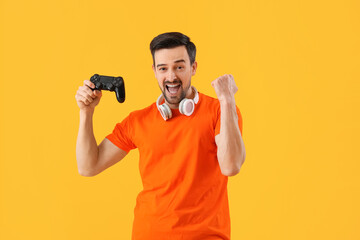 Poster - Handsome man with game pad on yellow background