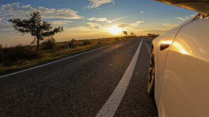 Wall Mural - LENS FLARE: Car travelling in golden sunlight through bushy Adriatic landscape