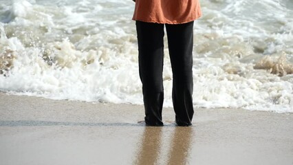 Wall Mural - Slow motion woman leg enjoying the beach sea wave