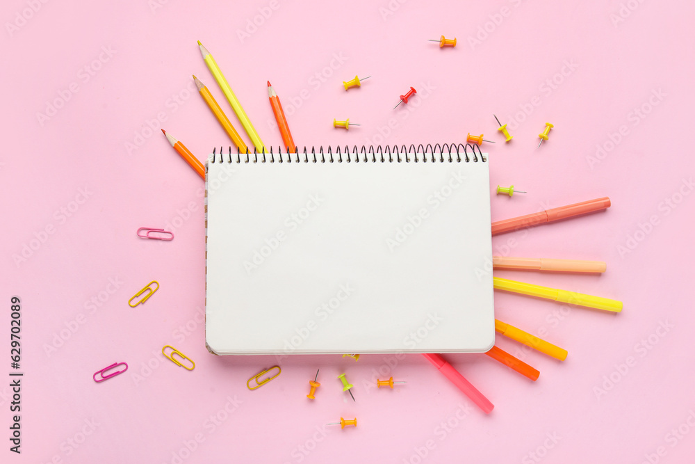 Composition with blank notebook and different stationery on pink background