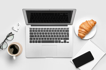 Modern gadgets, cup of coffee and croissant on white background