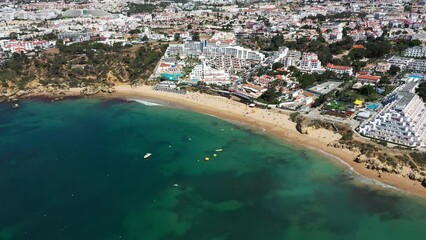 Wall Mural - Aerial footage of the beautiful beach front of Albufeira in Portugal, showing the Praia da Oura Beach and the waves crashing on the golden sandy beaches on a sunny summers day