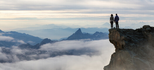 Wall Mural - Epic Adventure Composite of Hikers on top of a rocky mountain.