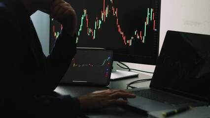 Sticker - Back view of stock market broker in analyzing data and graphs on multiple computer screens while sitting in modern office.