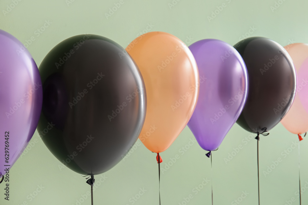 Different Halloween balloons on green background, closeup
