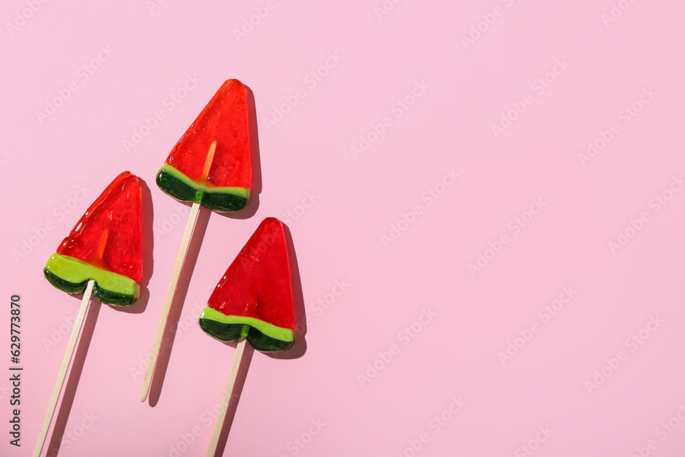 Lollipops in shape of watermelon slice on pink background